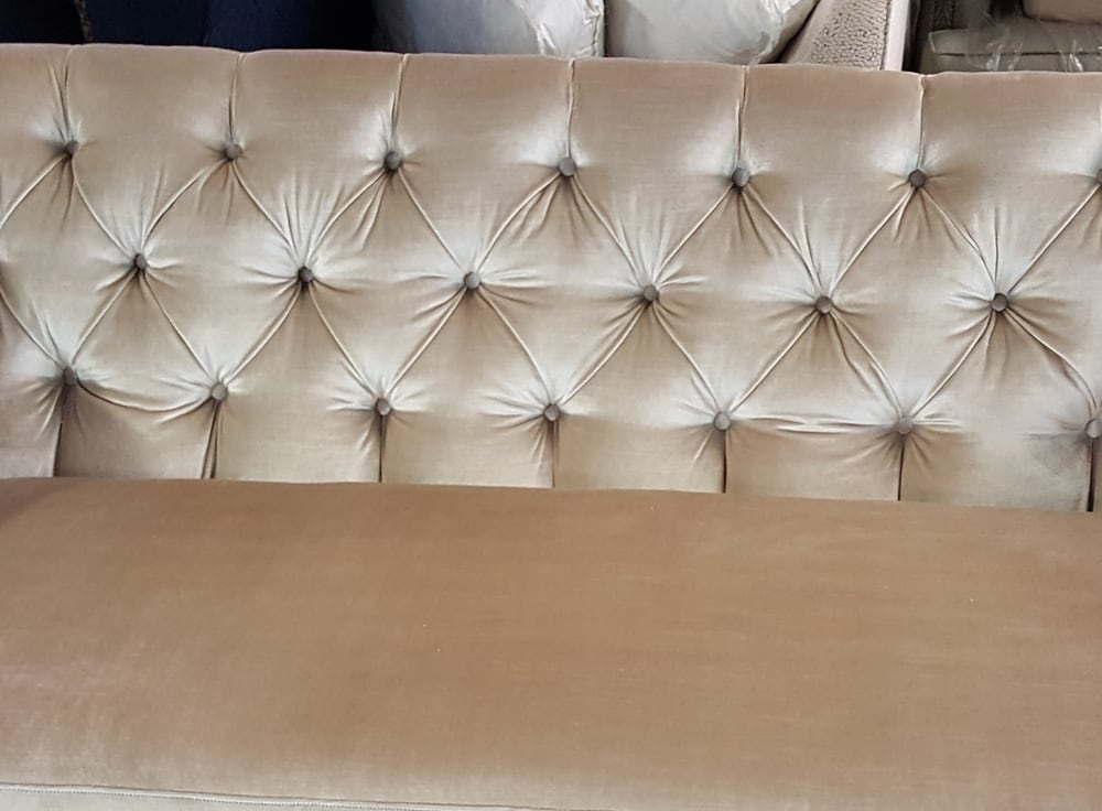 Close-up of diamond button tufting on velvet upholstery